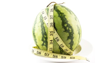 Diyet kavramı. Beyaz arka planda izole edilmiş mezura ile taze yeşil kavun.