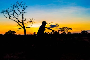 Gün batımında gökyüzü arka planında dağ bisikleti silueti