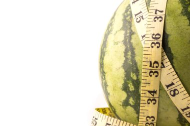 Diyet kavramı. Beyaz arka planda izole edilmiş mezura ile taze yeşil kavun.