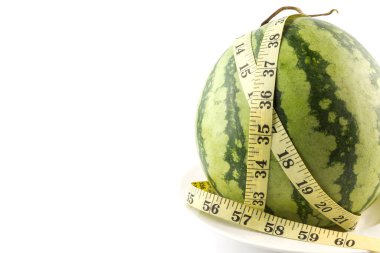 Diyet kavramı. Beyaz arka planda izole edilmiş mezura ile taze yeşil kavun.