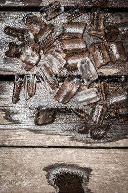 Kahverengi tahta arka planda buzlar eriyor.