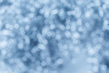 Işıklar arka planda parlıyor. Parlak bir arkaplan. Bokeh gümüş ışıklarla odaklanmış.