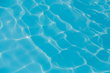 Güneşi yansıtan mavi havuz suyu