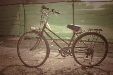 Kumda yeşil arka planı olan siyah bir bisiklet.