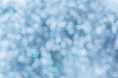 Işıklar arka planda parlıyor. Parlak bir arkaplan. Bokeh gümüş ışıklarla odaklanmış.