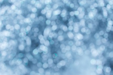 Işıklar arka planda parlıyor. Parlak bir arkaplan. Bokeh gümüş ışıklarla odaklanmış.