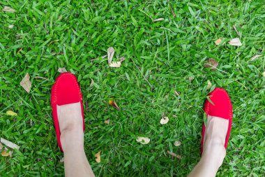 Yeşil çimenli kırmızı ayakkabılı kız