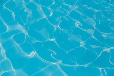 Güneşi yansıtan mavi havuz suyu