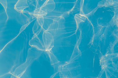 Güneşi yansıtan mavi havuz suyu