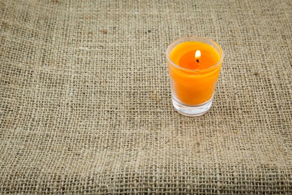 Orange Candle Glass Brown Sackcloth Texture Background — Stock Photo, Image