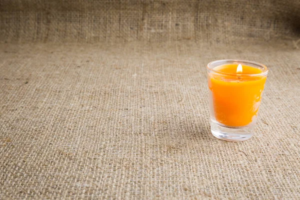 Orange Kerze Einem Glas Mit Braunem Sacktuch Textur Hintergrund — Stockfoto