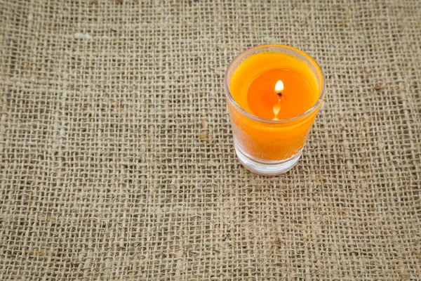 Orange Candle Glass Brown Sackcloth Texture Background — Stock Photo, Image