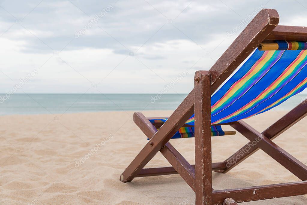 Beach chair on the sand with sea and sky background
