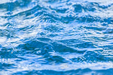 Su yüzeyindeki parlak mavi dalgalar.