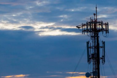 Günbatımından önce gökyüzü ve bulutlu kara siluet hücre kulesi arka plan için kullanılacak