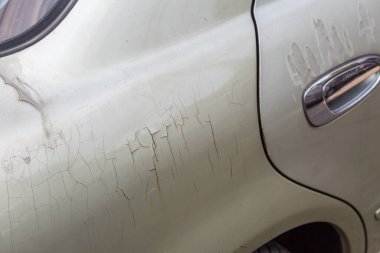 Araba arka planında çatlak ve soyulmuş boya.