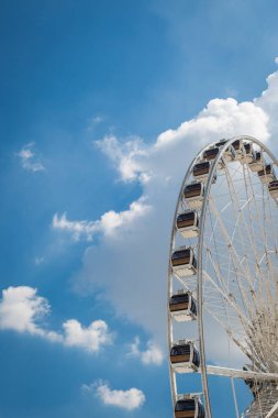 Beyaz büyük dönme dolap mavi gökyüzü keskin bulutlar arka plan