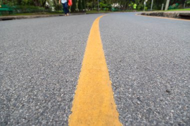 Halk parkındaki sarı çizgiyi kapatın. İnsanlar sağlık geçmişi için egzersiz yapıyor ve bisiklete biniyorlar.