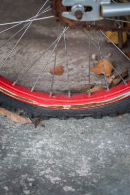 Patlak bisiklet lastiğini kapatın. Eski ve çimento arka planında pas var.