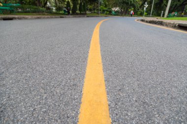 Halk parkındaki sarı çizgiyi kapatın. İnsanlar sağlık geçmişi için egzersiz yapıyor ve bisiklete biniyorlar.