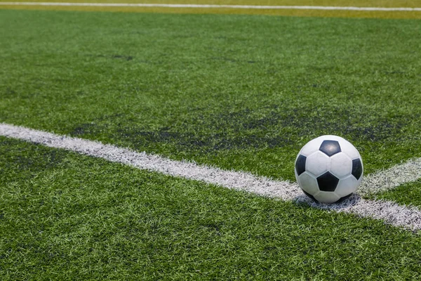 緑のサッカー場の芝生の背景に白い線のサッカーボール — ストック写真