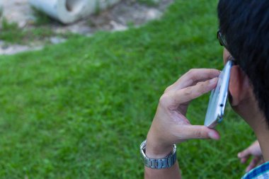 Yeşil arka planda cep telefonu kullanan bir adamı kapat.