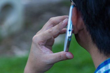 Yeşil arka planda cep telefonu kullanan bir adamı kapat.