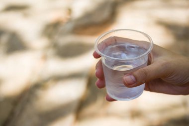 Su bardağı tutan bir kadın.