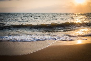 Sahilde günbatımı dalgaları