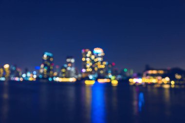Şehrin aydınlık bokeh 'i gece arkaplanında nehirde