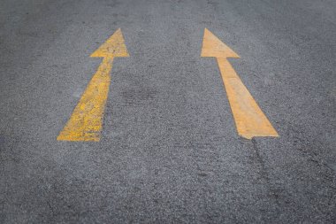 İki sarı ok eski ve asfalt yol arka planında yeni yön