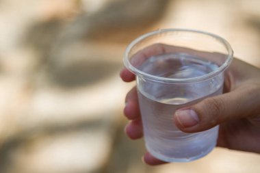 Su bardağı tutan bir kadın.