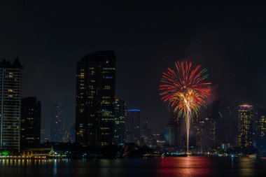 Gece karanlığında kutlama için nehirde güzel havai fişekler.