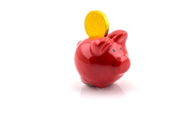 Beyaz arka planda izole edilmiş kırmızı domuz bankasına büyük altın sikke