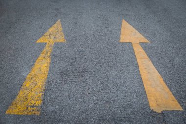 İki sarı ok eski ve asfalt yol arka planında yeni yön