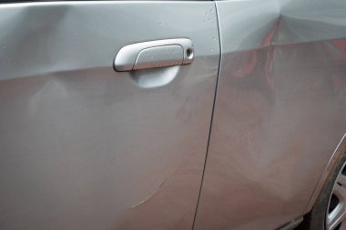 Yağmurlu bir günde sol tarafındaki göçükle kaza sonucu hasar görmüş bir araba.