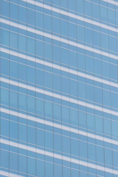 Modern office building with blue glass windows background