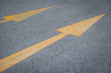 İki sarı ok eski ve asfalt yol arka planında yeni yön