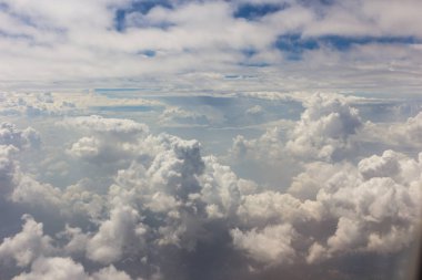 Bulutlu mavi gökyüzü ve hava planında kara parçası olan beyaz bulut