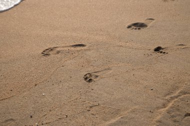 Sahilde baba ve çocuğun ayak izleri var.