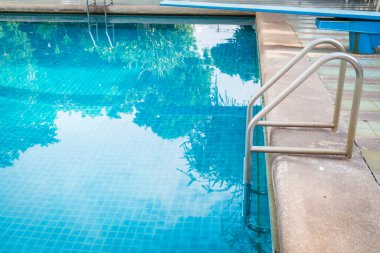 Mavi yüzme havuzu arka planında parmaklık merdiveni