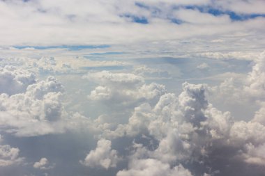 Bulutlu mavi gökyüzü ve hava planında kara parçası olan beyaz bulut