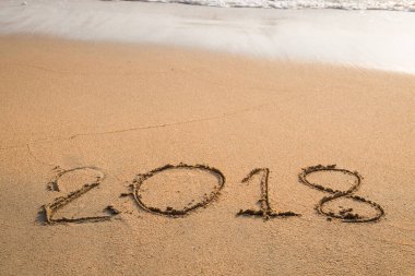 2018 plaj arka planındaki kuma yazılmış bir mesaj.