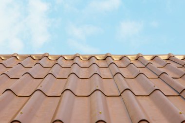 Mavi gökyüzü arka planında fayanslı çatılı çatı evi