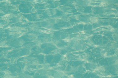 Güneşi yansıtan mavi havuz suyu