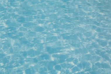 Güneşi yansıtan mavi havuz suyu