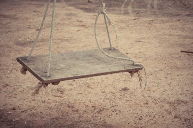 Arka bahçede ipte eski ahşap salıncak