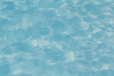 Güneşi yansıtan mavi havuz suyu