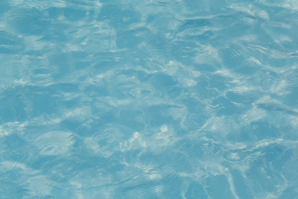 Güneşi yansıtan mavi havuz suyu