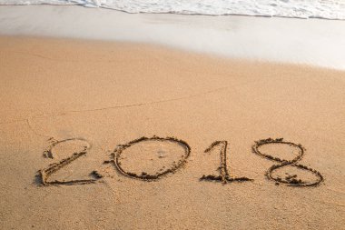 2018 plaj arka planındaki kuma yazılmış bir mesaj.